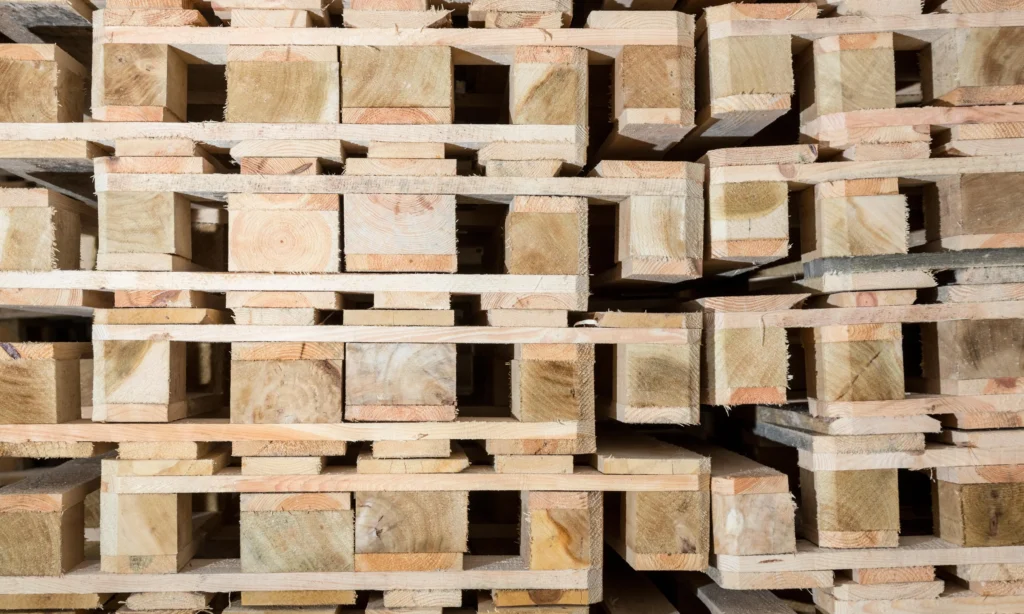 Stosy nowych palet drewnianych, świeżo wyprodukowane. Solidne i trwałe palety gotowe do transportu i magazynowania towarów.