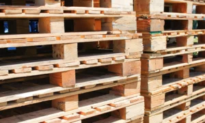 Stos drewnianych palet gotowych do użycia w logistyce. Palety drewniane są popularnym wyborem w transporcie i magazynowaniu towarów.