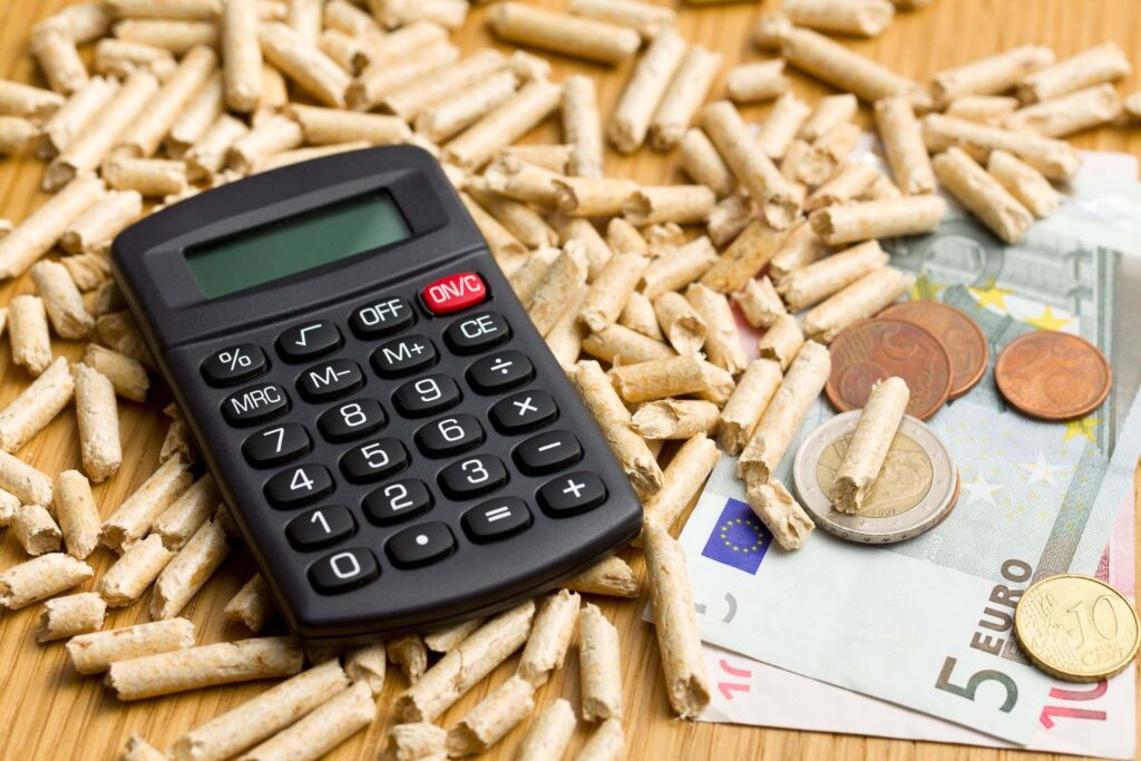 Pellet drzewny z kalkulatorem, banknotami oraz monetami.