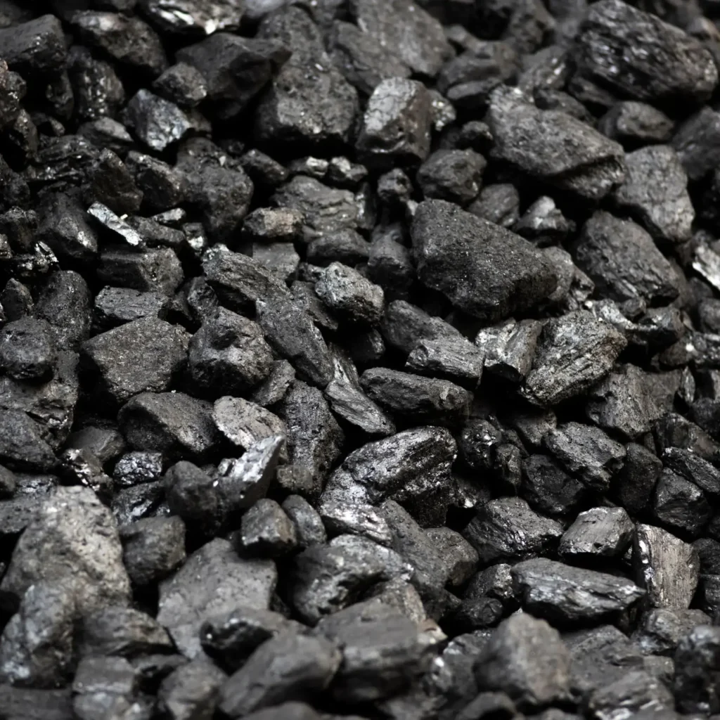 Zdjęcie przedstawia bryły węgla kamiennego, czarnego surowca energetycznego używanego głównie do produkcji energii i ciepła.